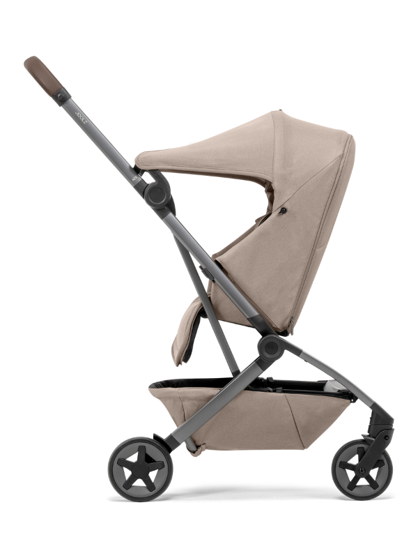 Detalle lateral de la Joolz Aer&sup2; en color beige sobre fondo naranja, destacando su dise&ntilde;o ergon&oacute;mico.